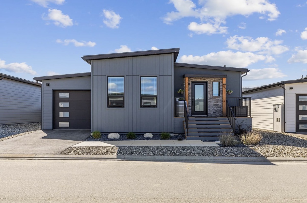 Modern grey modular home with attached garage and stone entry, British Columbia